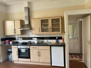 a kitchen with wooden cabinets and a sink at Penzance Central 1 & 2 Bedroom flats in Penzance