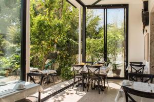 - un restaurant avec des tables, des chaises et de grandes fenêtres dans l'établissement Casa do Barao, à Lisbonne