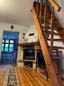 a living room with a staircase and a fireplace at Chatka mojego dziadka in Długie