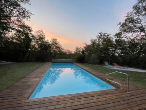 a swimming pool on a wooden deck with at Le Mas d'Angèle in Saint-Chamarand