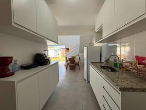 カボ・フリオにあるDunas do Peró, Cabo Frio 01の白いキャビネットとカウンタートップを備えたキッチン
