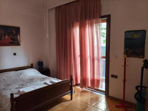 a bedroom with a bed and a large window at Apartment with Garden in Amarinthos