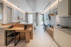 une cuisine et un salon avec une table et un lit dans l'établissement Hospi Living Stalida Beachfront Suites with Heated Jacuzzi, à Stalida