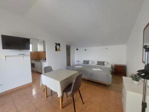 une chambre avec un lit et une table et une cuisine dans l'établissement Apartments Oliva, à Podgora
