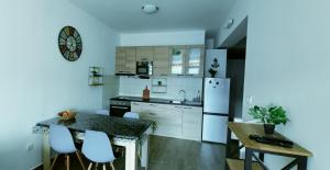 a kitchen with white appliances and a table and chairs at Appartement Carpe diem vue mer in Herceg-Novi +14 photos