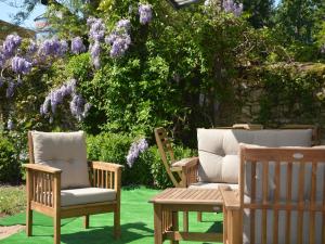 two chairs and a table in a yard with purple flowers at Mansion in Champvert with Pond View Terrace in Champvert