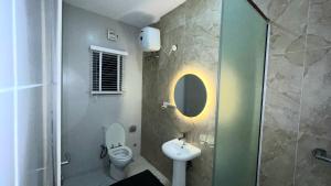 Un baño con inodoro, lavabo y ducha. en Pj Apartment, en Lekki