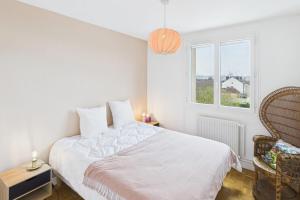 Una habitación blanca con una cama y una ventana en Savinéa, en Sainte-Savine