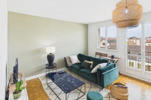 Una sala de estar con un sofá verde y una ventana. en Savinéa, en Sainte-Savine 3 fotos más