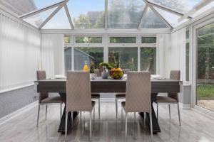 a dining room with a table and chairs in a conservatory at 6 Bedrooms, Driveway Parking, Pool Table, Netflix, Huge Long Term Savings in Great Sankey +20 photos