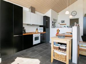 a kitchen with black and white cabinets and a table at 4 star holiday home in Brovst in Brovst
