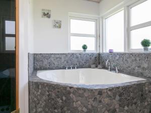 a large tub in a bathroom with two windows at 4 star holiday home in Brovst in Brovst
