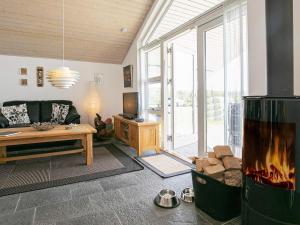 a living room with a fireplace and a couch at 4 star holiday home in Brovst in Brovst +33 photos