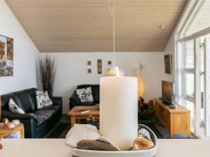 a candle sitting on a table in a living room at 4 star holiday home in Brovst in Brovst