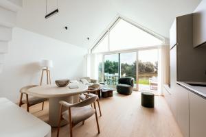 a living room with a table and chairs and a large window at Chalet Eau Vive Mase - Luxe vakantiewoning in Maaseik aan de Maas in Maaseik