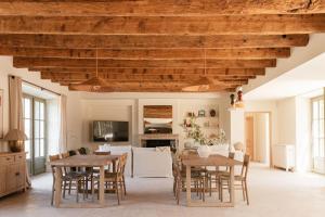 a living room with wooden ceilings and tables and chairs at Mas de l'Etoile in Aureille