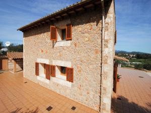 a brick building with brown shuttered windows on it at Villa in Mallorca with Private Pool in Marratxi