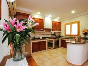 a kitchen with a vase of pink flowers on a table at Villa in Mallorca with Private Pool in Marratxi