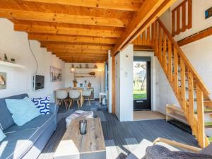 a living room with a blue couch and a table at Holiday Home near Beach with Pool Access in Burgh Haamstede