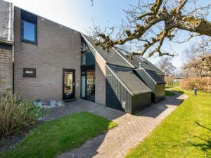 a brick house with a pitched roof at Holiday Home near Beach with Pool Access in Burgh Haamstede