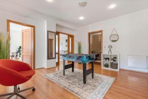 a living room with a ping pong table and a chair at Exclusive Apartment in Centre in Bratislava