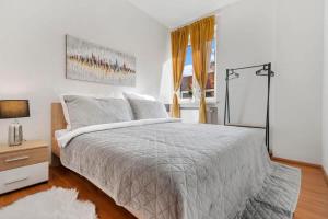 a white bedroom with a large bed and a window at Exclusive Apartment in Centre in Bratislava