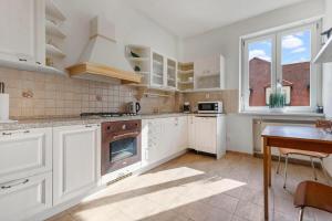 a kitchen with white cabinets and a table and a window at Exclusive Apartment in Centre in Bratislava