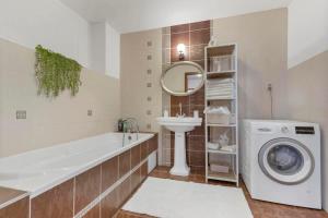 a bathroom with a tub sink and a washing machine at Exclusive Apartment in Centre in Bratislava +13 photos