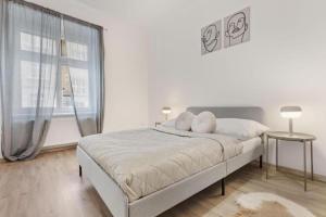 Un dormitorio blanco con una cama y una ventana. en City Center Suite - Modern & Stylish, en Bratislava