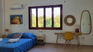 a bedroom with a bed and a desk and a mirror at Aegean Villa & Garden in Faliraki in Faliraki
