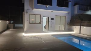 a room with a swimming pool with lights on it at Yama's Villa - Polyxenia luxury, protaras, cyprus in Protaras +15 photos