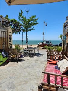 a beach with a bench and a table and the ocean at Dongfang City Erlihai Youth Hostel 