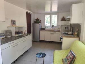 eine Küche mit weißen Schränken und einem gelben Stuhl darin in der Unterkunft La maison de Quitterie in Aire-sur-lʼAdour