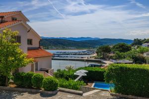 a house with a swimming pool and a view of a marina at Apartments Tariba in Supetarska Draga