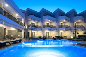 an apartment building with a swimming pool at night at Leon Villas in Nikiti