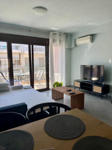 a living room with a table and a television at SnappyB Living Spaces in Alexandroupoli