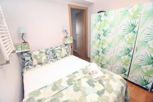 ein Schlafzimmer mit einem Bett mit einer grünen und weißen Decke in der Unterkunft EL RINCON DEL MARQUES entresuelo Junto a Catedral in Logroño