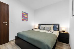 a bedroom with a large bed with two night stands at Modern and Cozy flat with Balcony in Bratislava