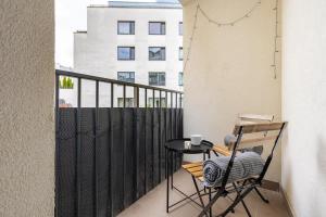 a small table and chair on a balcony with a building at Modern and Cozy flat with Balcony in Bratislava