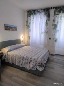 a bedroom with a bed in a room with curtains at Malpensa Sleep & Go in Somma Lombardo