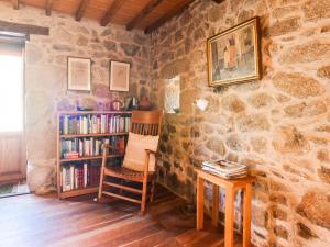 ein Zimmer mit einem Stuhl und einem Bücherregal mit Büchern in der Unterkunft Farmhouse in Castrotañe with Terrace in Castillón