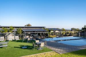 Un patio con mesa y sillas junto a una piscina. en #AlimamaSpaces The Manson Umthunzi View, en Vosburg