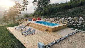 una piscina con dos sillas y una mesa en Cabana Sub Stejari 2, en Râșnov