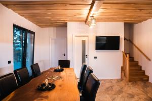 Un comedor con una larga mesa de madera y sillas. en Cabana Sub Stejari 2, en Râșnov
