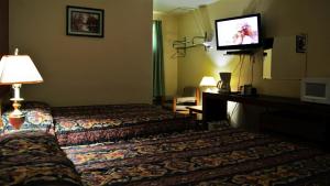 a hotel room with a bed and a flat screen tv at Blue Jay Motel in Peterborough