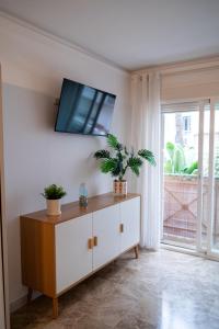 a living room with a tv on a white wall at CT 394 - Faro's Beach & Town - Torremolinos in Torremolinos +22 photos