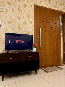 a tv sitting on top of a dresser next to a door at Luxe 1BHK Apartment with Pool and Sauna in Islamabad +3 photos