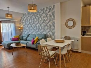 a living room with a blue couch and a table at Apartamento Mar y Rocas in Malpica