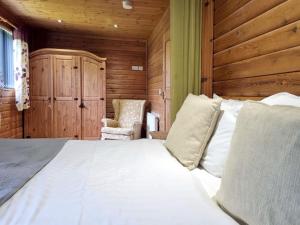 a bedroom with a large bed and a chair at Oak 10 Hot Tub in Garton