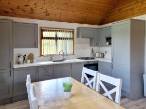 a kitchen with a wooden table and a table and chairs at Oak 10 Hot Tub in Garton